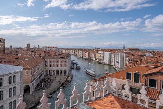 Breathtaking aerial view of Venice's Grand Canal with historic architecture under a sunny sky.