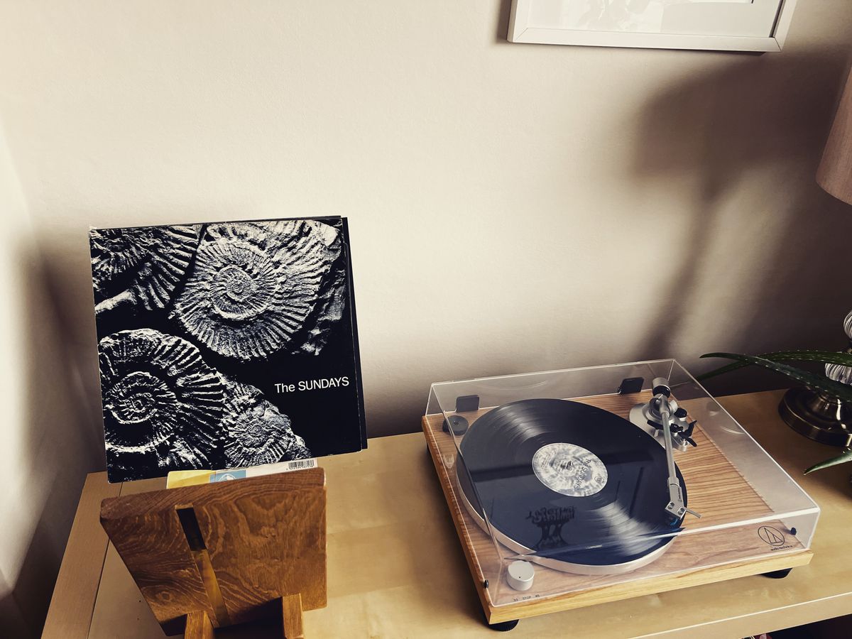 Vintage turntable playing a vinyl record beside its album cover, for a music trivia round, trivia night party ideas