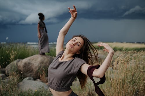 A Woman in Gray Shirt Dancing on the Field