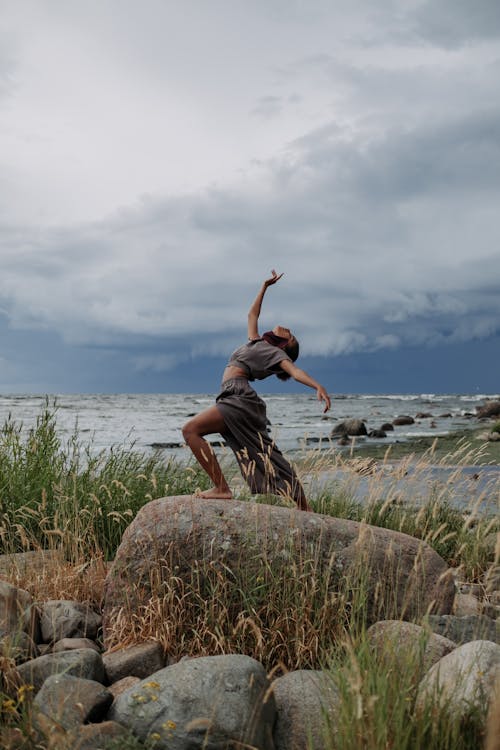 Free Woman Dancing on Top of a Big Rock Stock Photo