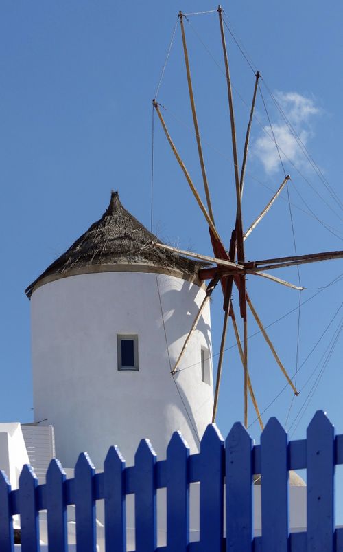 Free Iconic white windmill and blue fence against clear sky in Santorini. Stock Photo