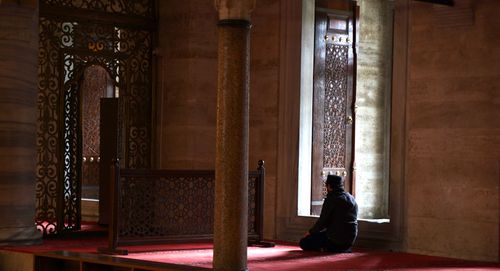Free A man in silent prayer inside a historic mosque in Istanbul, Türkiye, showcasing spiritual devotion. Stock Photo
