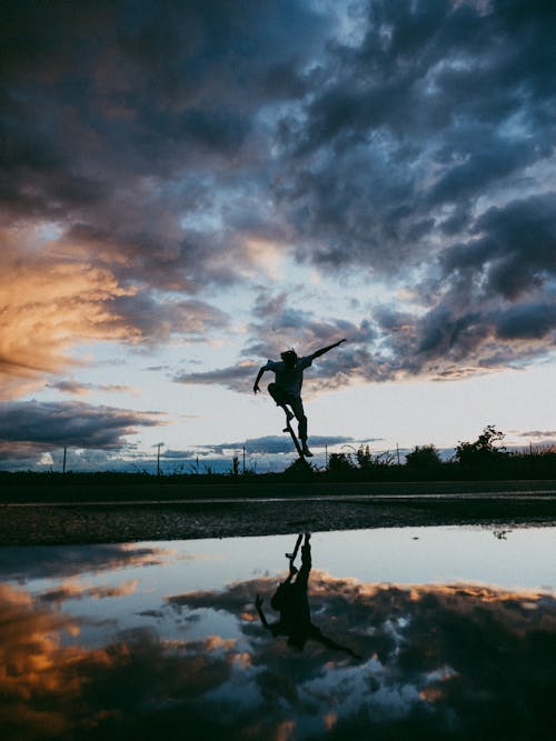 A Silhouette of a Person Jumping with a Skateboard