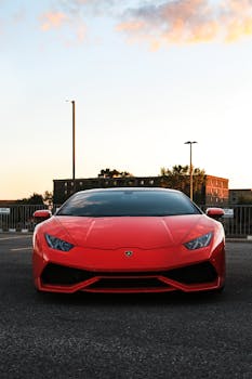 A striking red sports car parked on an urban road at sunset, showcasing luxury and style.