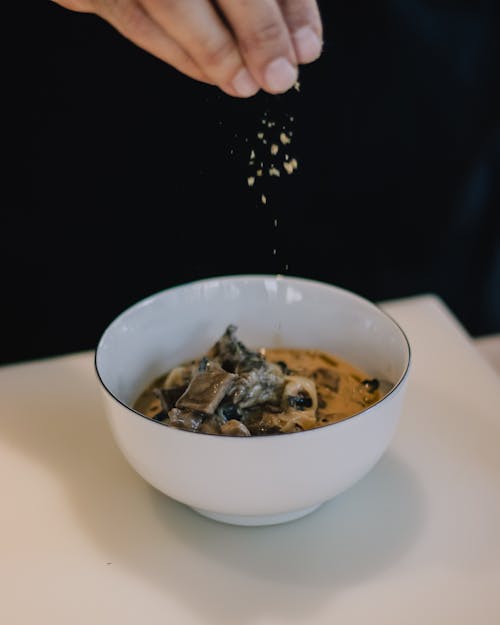 Close-up of Man Salting a Dish in a Bowl