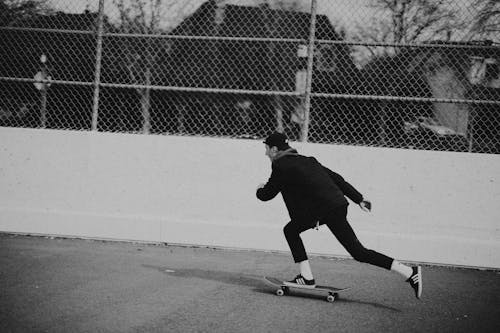 Man Riding a Skateboard in Black and White Photography