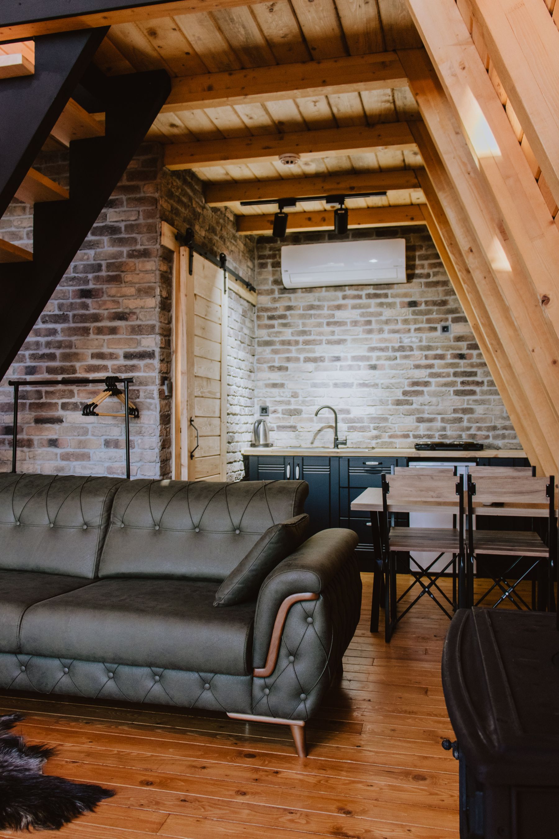 Brown leather sofa beside wood and metal furniture in a warm living room