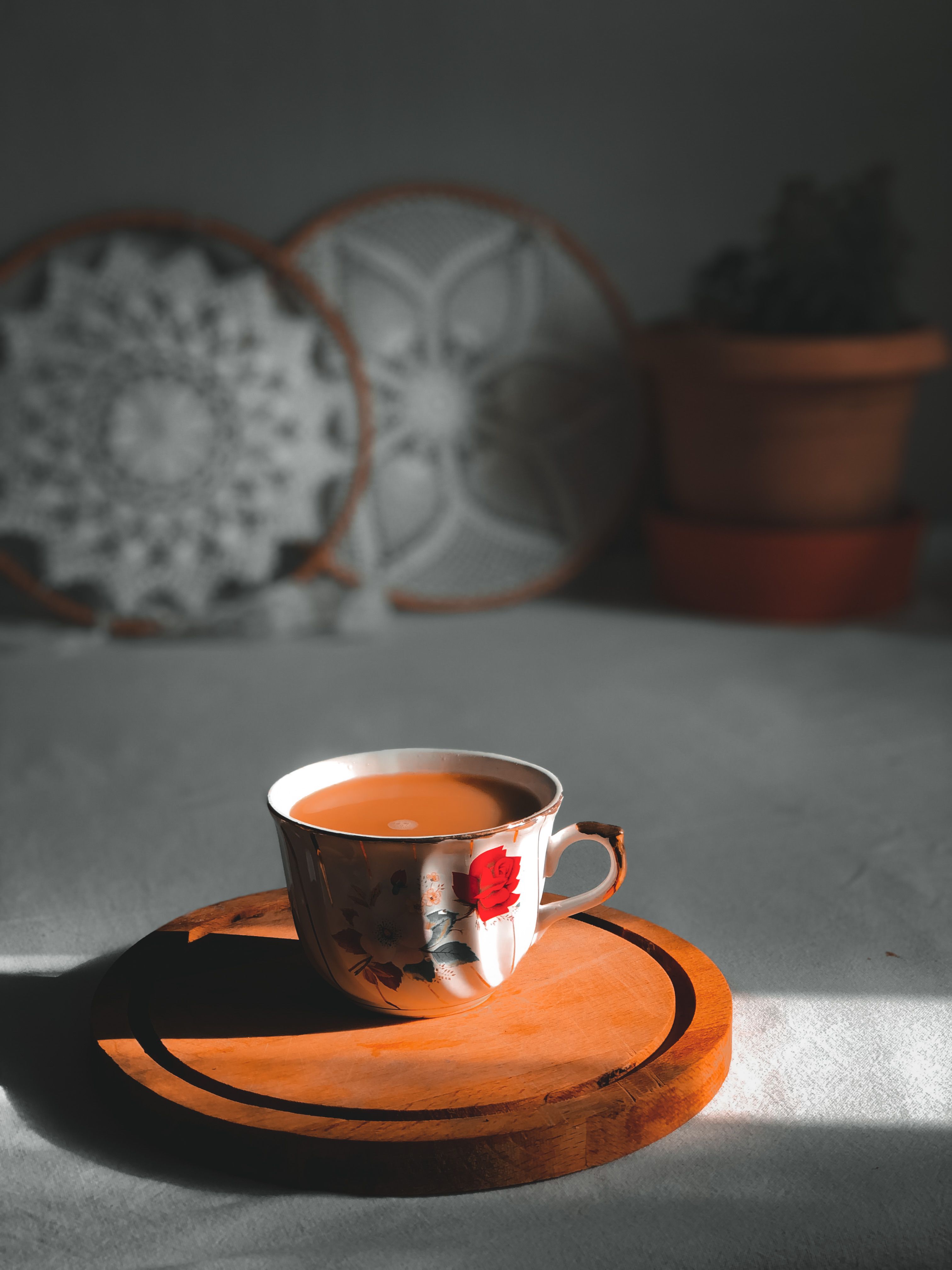 Set of weathered distressed wooden coasters arranged on a boho coffee bar counter next to mugs