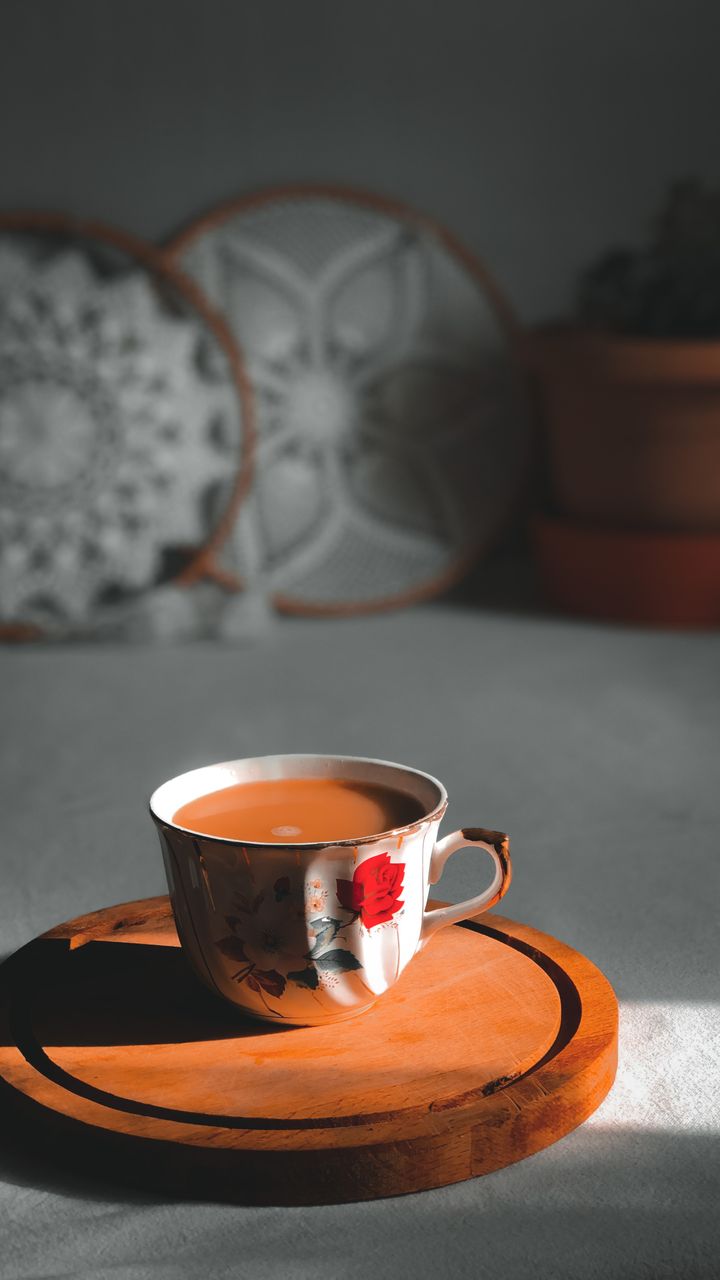 Set of weathered distressed wooden coasters arranged on a boho coffee bar counter next to mugs
