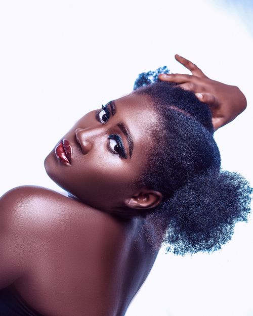 Free Close-up portrait of a woman posing elegantly with natural hairstyle and red lipstick. Stock Photo