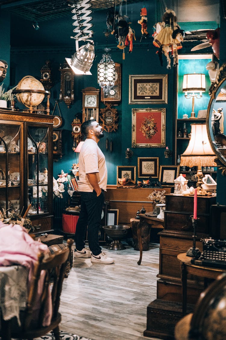 A Man In White Shirt Standing Inside An Antique Shop