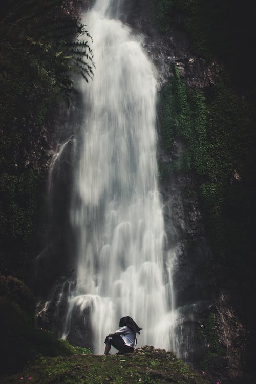 Free Photo of Man Sitting Near Waterfalls Stock Photo