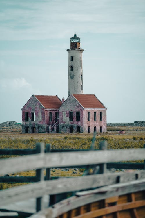 A Brown and Grey Abandoned Building with Tower in a Grass Field