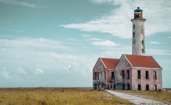 Abandoned lighthouse on Klein Curacao against a tranquil blue sky.