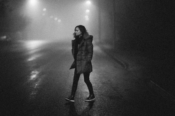 Woman walking a foggy street at night, photo by Alexey Demidov on Pexels