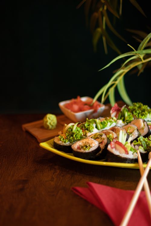Free A vibrant sushi platter featuring various sushi rolls, garnished with wasabi and vegetables, perfect for food enthusiasts. Stock Photo