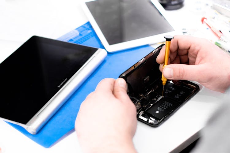 A Person Repairing A Smart Phone