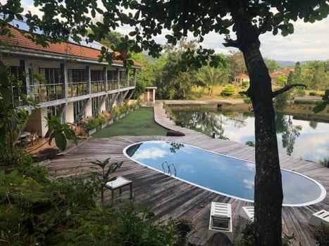 Relaxing resort in Cambodia featuring a serene poolside view, surrounded by lush greenery.
