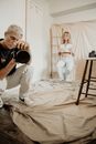 Man in White T-shirt and White Pants Holding Black Dslr Camera