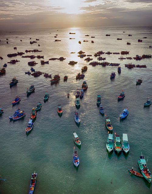 Free A stunning aerial view of fishing boats scattered across the ocean at sunset in Phu Quoc, Vietnam. Stock Photo