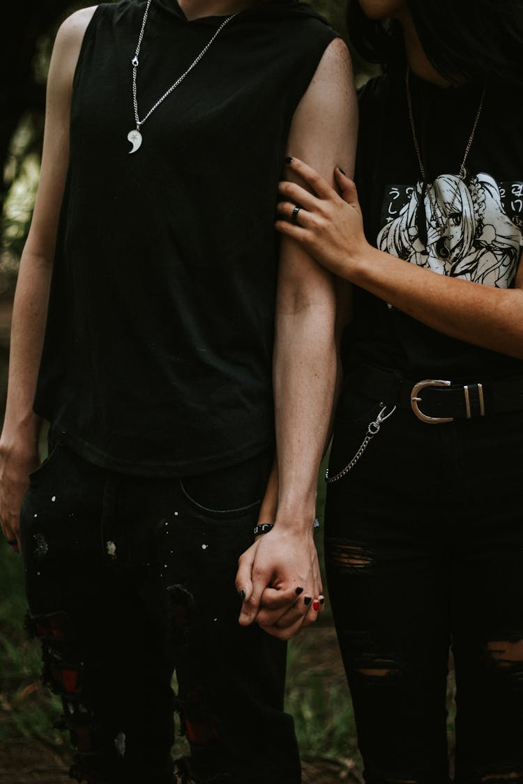 Couple Dressed In Black Holding Hands