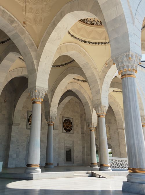 Free Elegant arches and marble columns defining the grand architecture of a mosque interior on a sunny day. Stock Photo