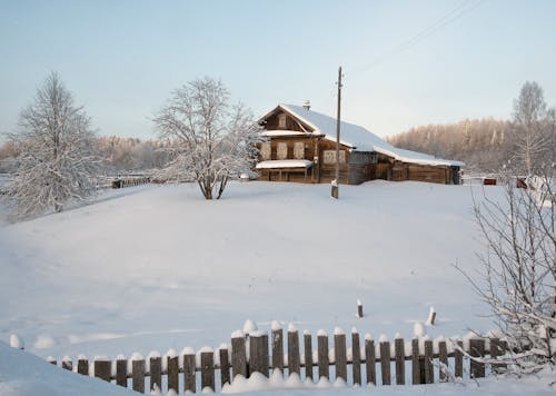 Brown Wooden House on Snow Covered Landscape