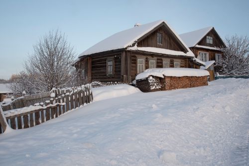 Free Rustic wooden cabins surrounded by snow and frost on a winter day Stock Photo