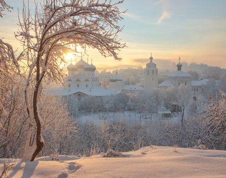 Beautiful winter scene with snow-covered church and trees at sunrise, capturing serene and tranquil atmosphere.