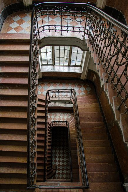 Capture of an ornate, spiral staircase in a historic building in Lviv, Ukraine, showcasing elegant ironwork.