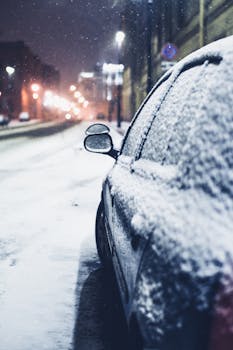 A snowy car parked on a street during a winter night in Saint Petersburg, Russia.