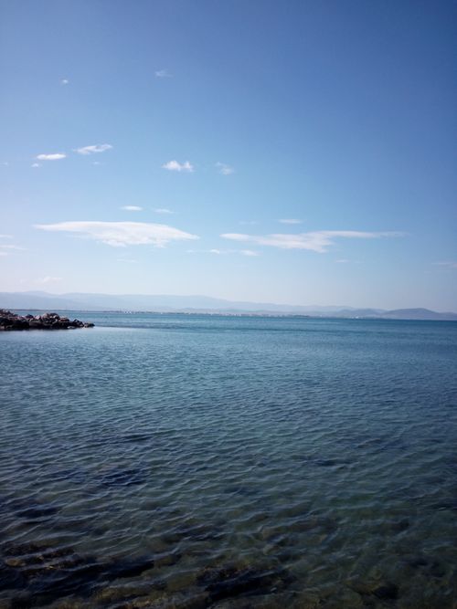 Free Peaceful seascape featuring clear skies, calm sea, and distant islands under a gentle daylight horizon. Stock Photo