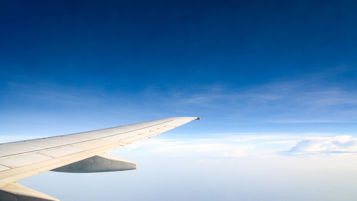 Airplane wing during flight offers a serene view of the sky and clouds.