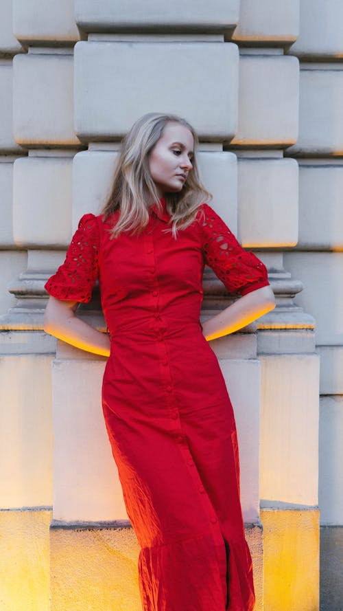 Woman in Red Dress Leaning Against Wall