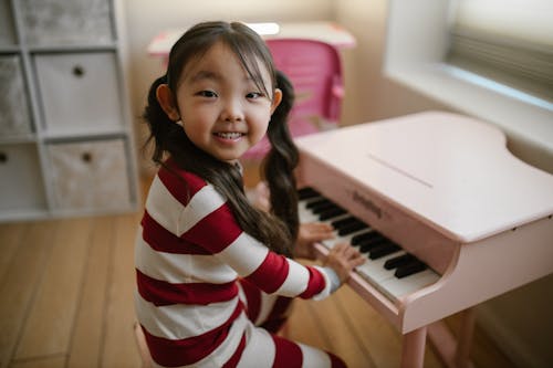 Free Cheerful Child by Toy Piano Stock Photo
