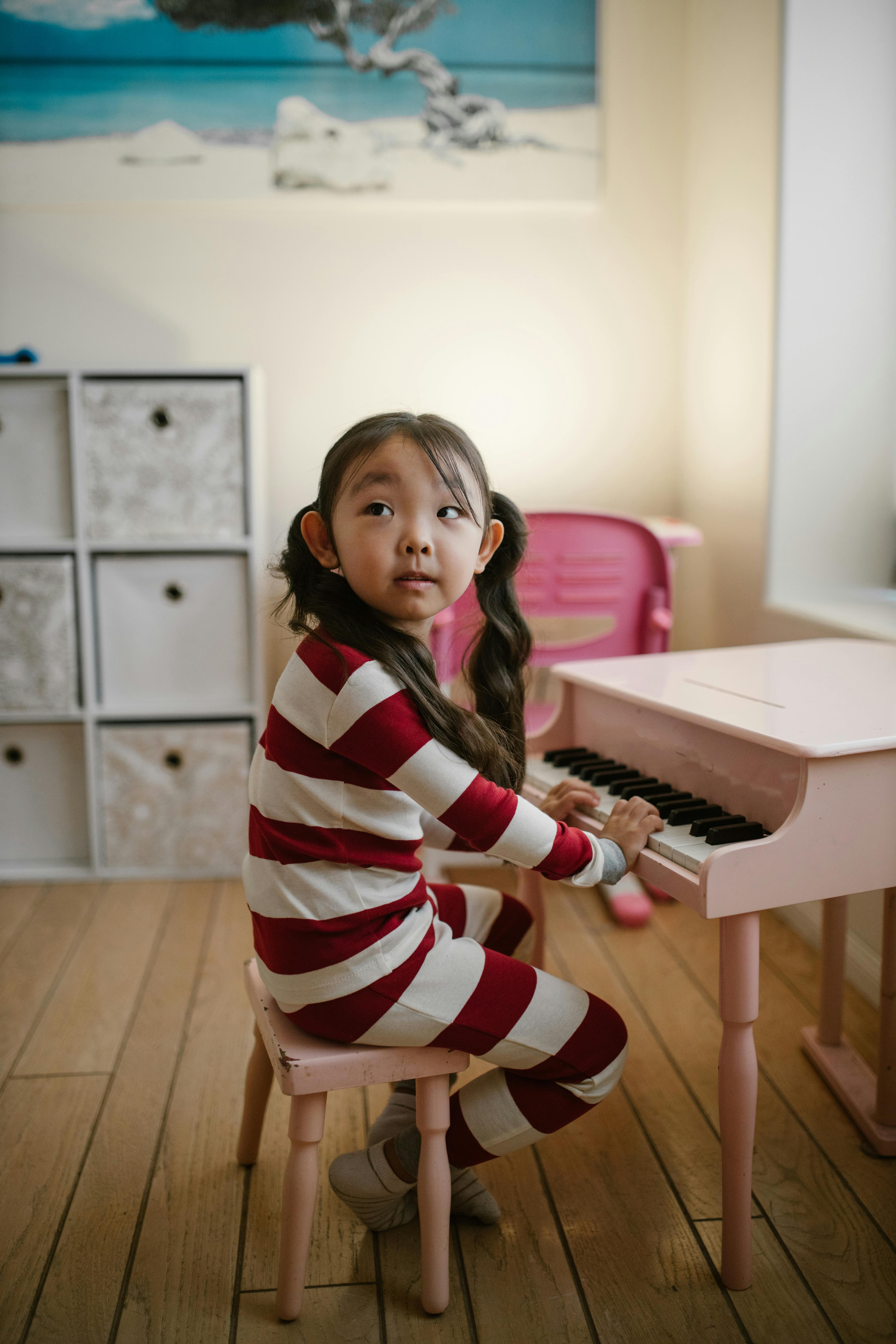 girl playing pink piano at home