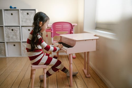 Free Girl Playing Toy Piano at Home Stock Photo