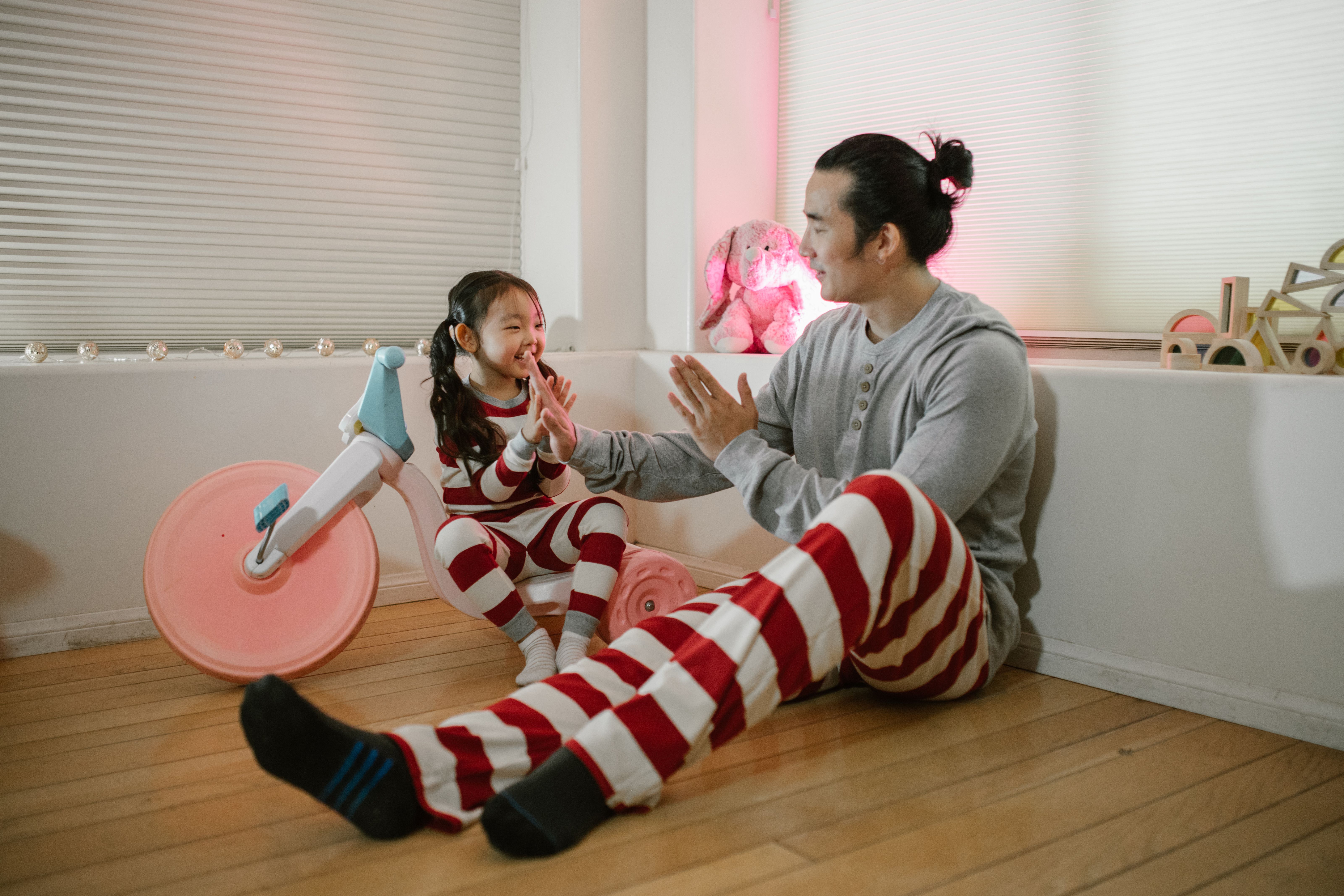 A father and daughter share a moment playing together indoors in matching pajamas. - Photo by RDNE Stock project on Pexels