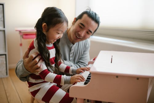 Free Father with Daughter Playing Toy Piano Stock Photo