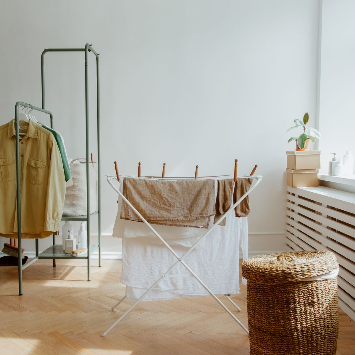 Roupas limpas secando em varal interno perto de uma janela iluminada
