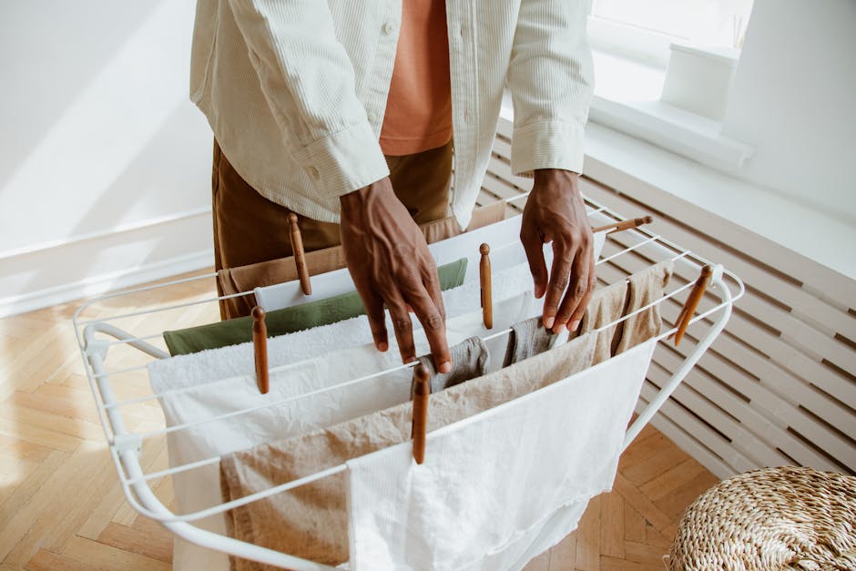 Kompaktowa zabudowa pralni w mieszkaniu z pralką i suszarką w kolumnie, kratka wentylacyjna i blat