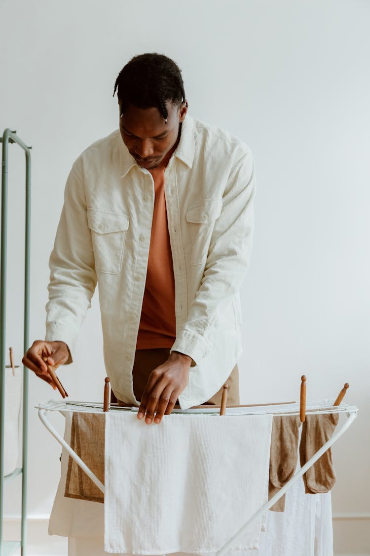 Man Using Clips While Hanging Laundry