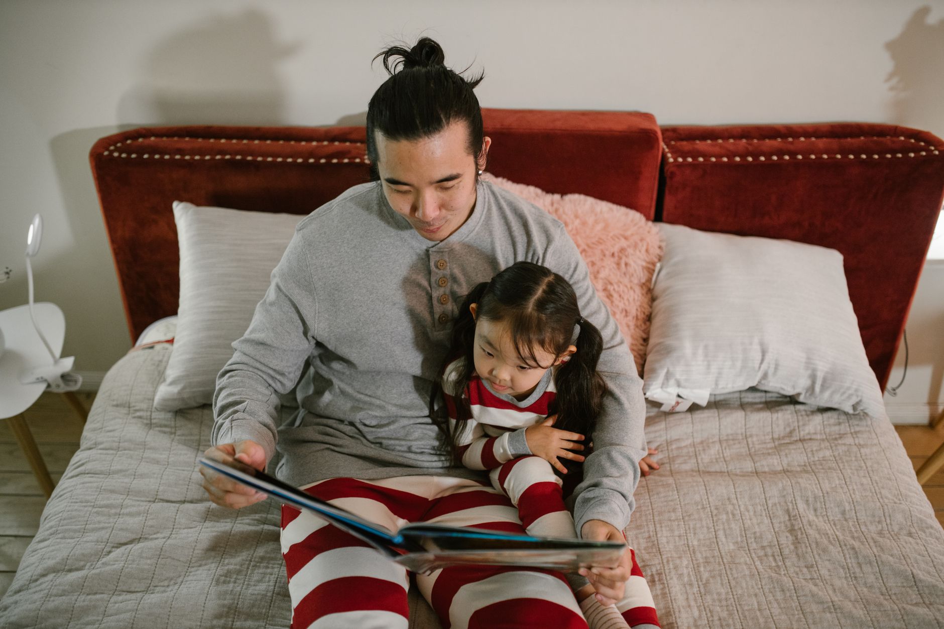 Father and daughter reading a bedtime story together, fostering bonding and family time.
