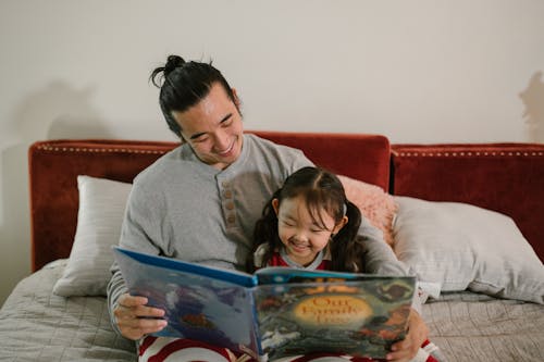 Free Father Reading Book with his Daughter Stock Photo
