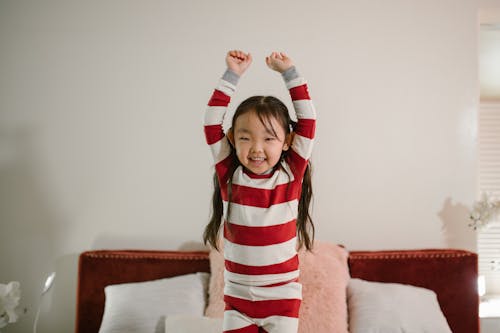 Free Child Standing on Bed Stock Photo