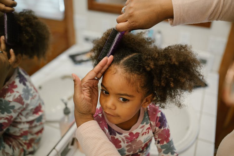 Mother Brushing Daughter Hair