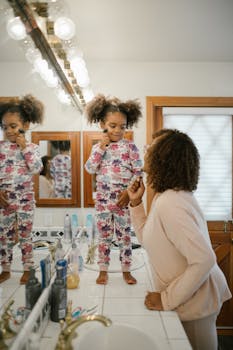 A joyful morning routine with mother and daughter using jade rollers in the bathroom.