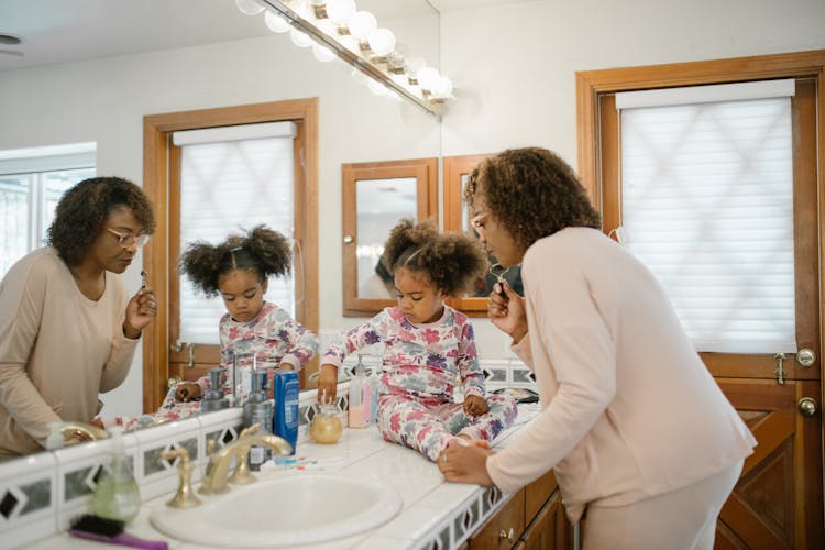 Mother And Daughter In Bathroom During Morning Routine