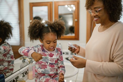A cheerful morning routine with a mother and daughter in the bathroom.