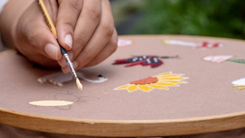 A Hand Painting a Brown Fabric